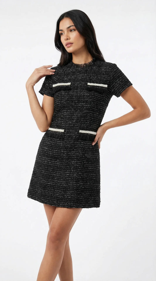 Woman wearing a black dress with white accents on a white background