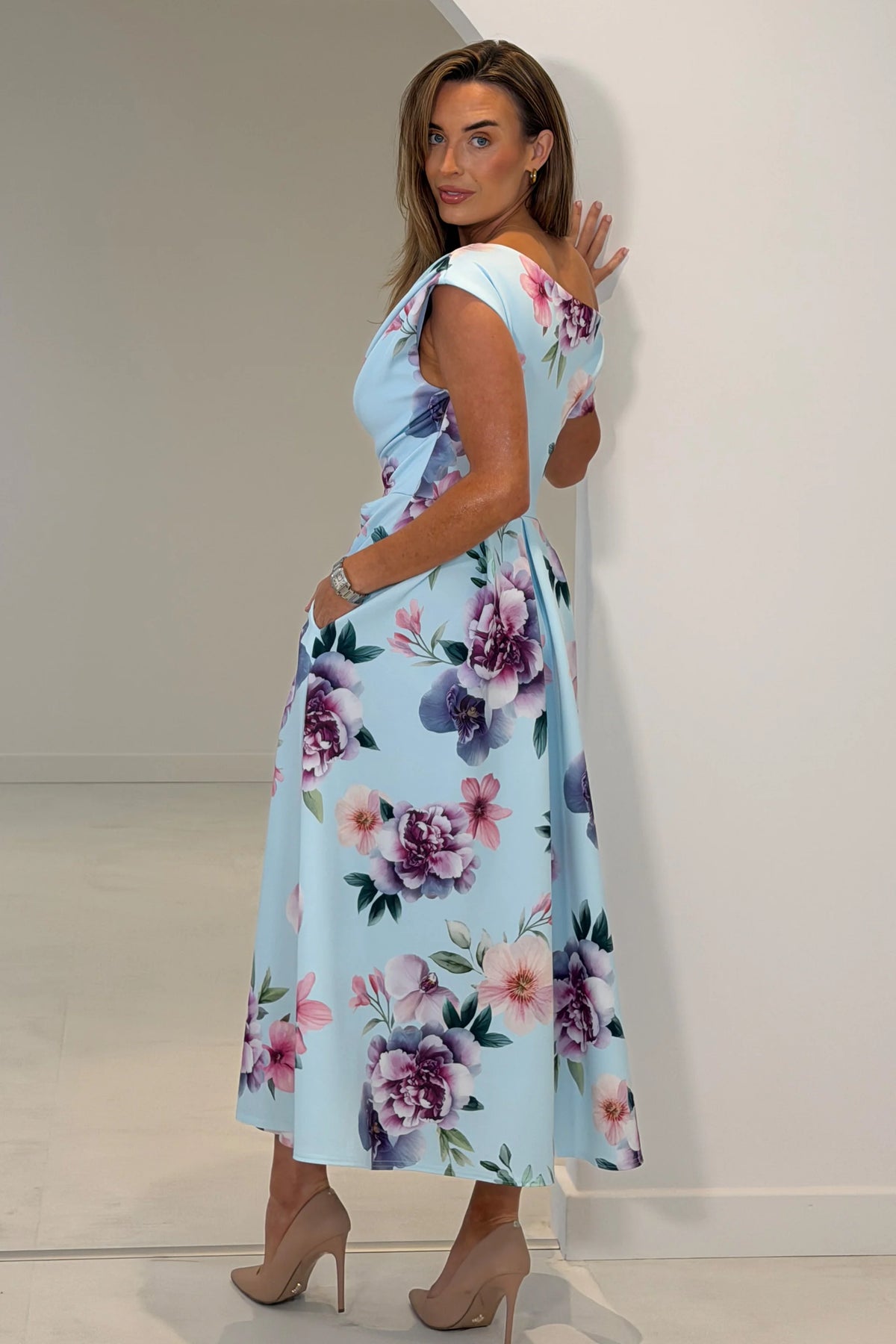 Woman wearing a floral dress with a plain background