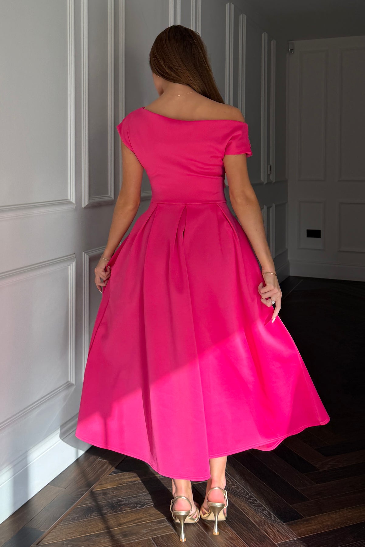 Woman wearing a bright pink dress in an indoor setting