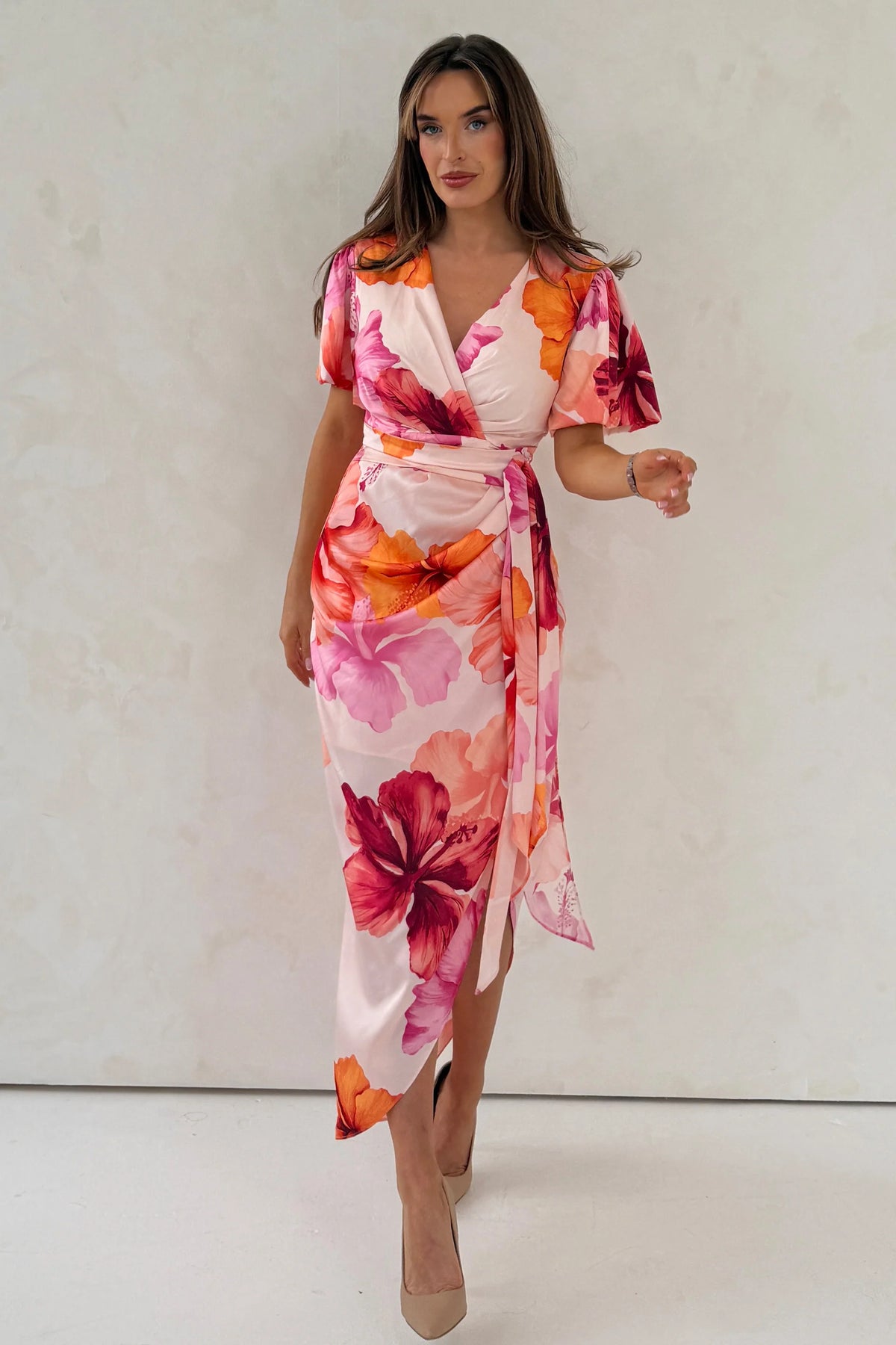 Woman wearing a floral dress with a plain background