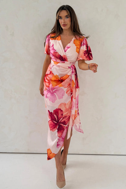 Woman wearing a floral dress with a plain background