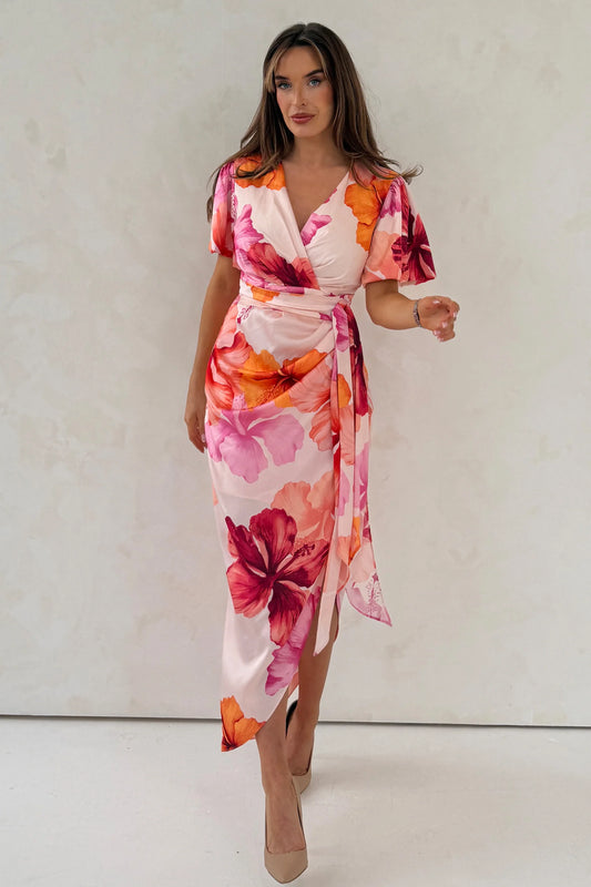 Woman wearing a floral dress with a plain background