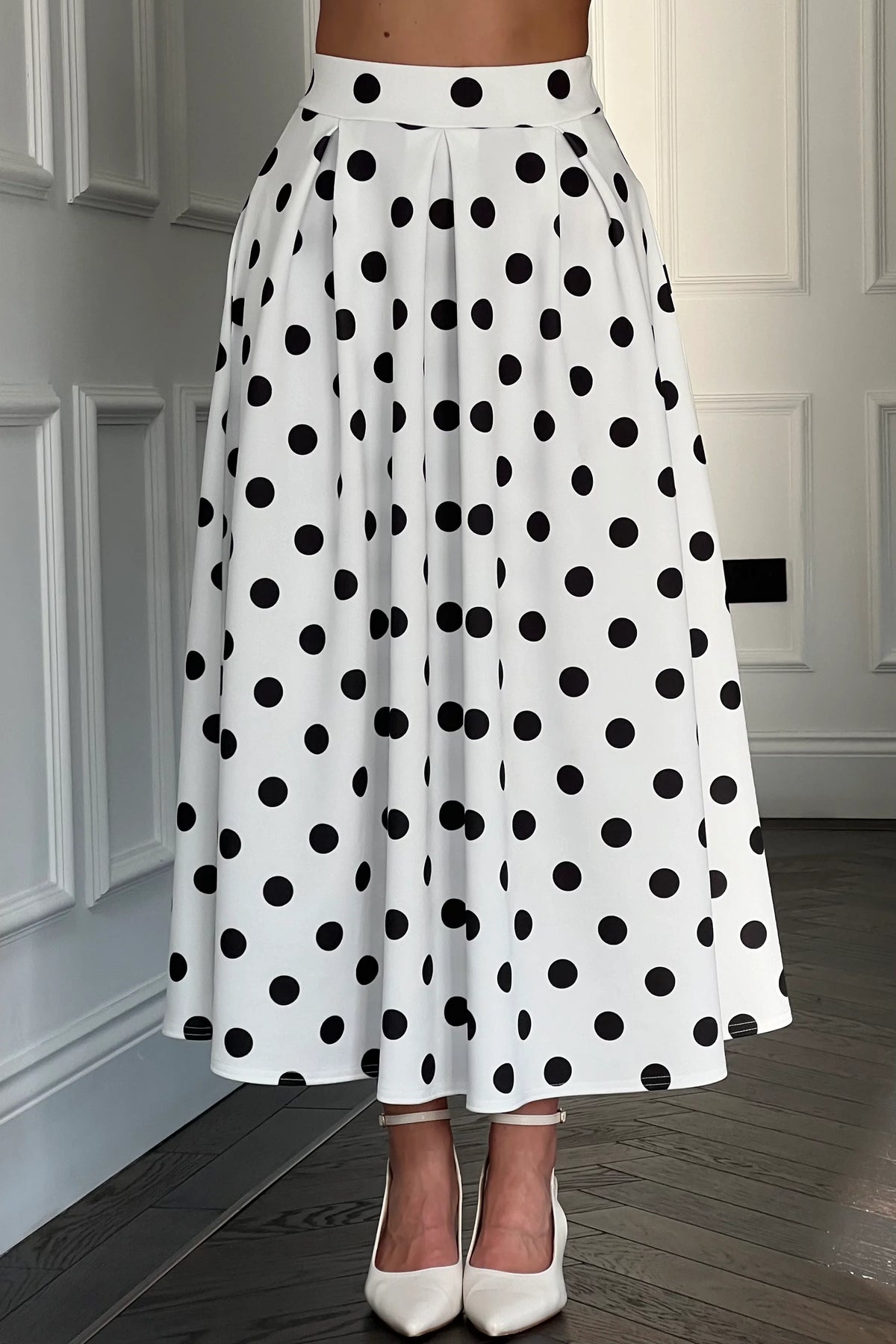 White skirt with black polka dots worn by a person indoors.