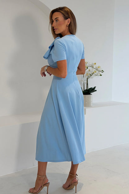 Woman wearing a light blue dress in a minimalistic setting