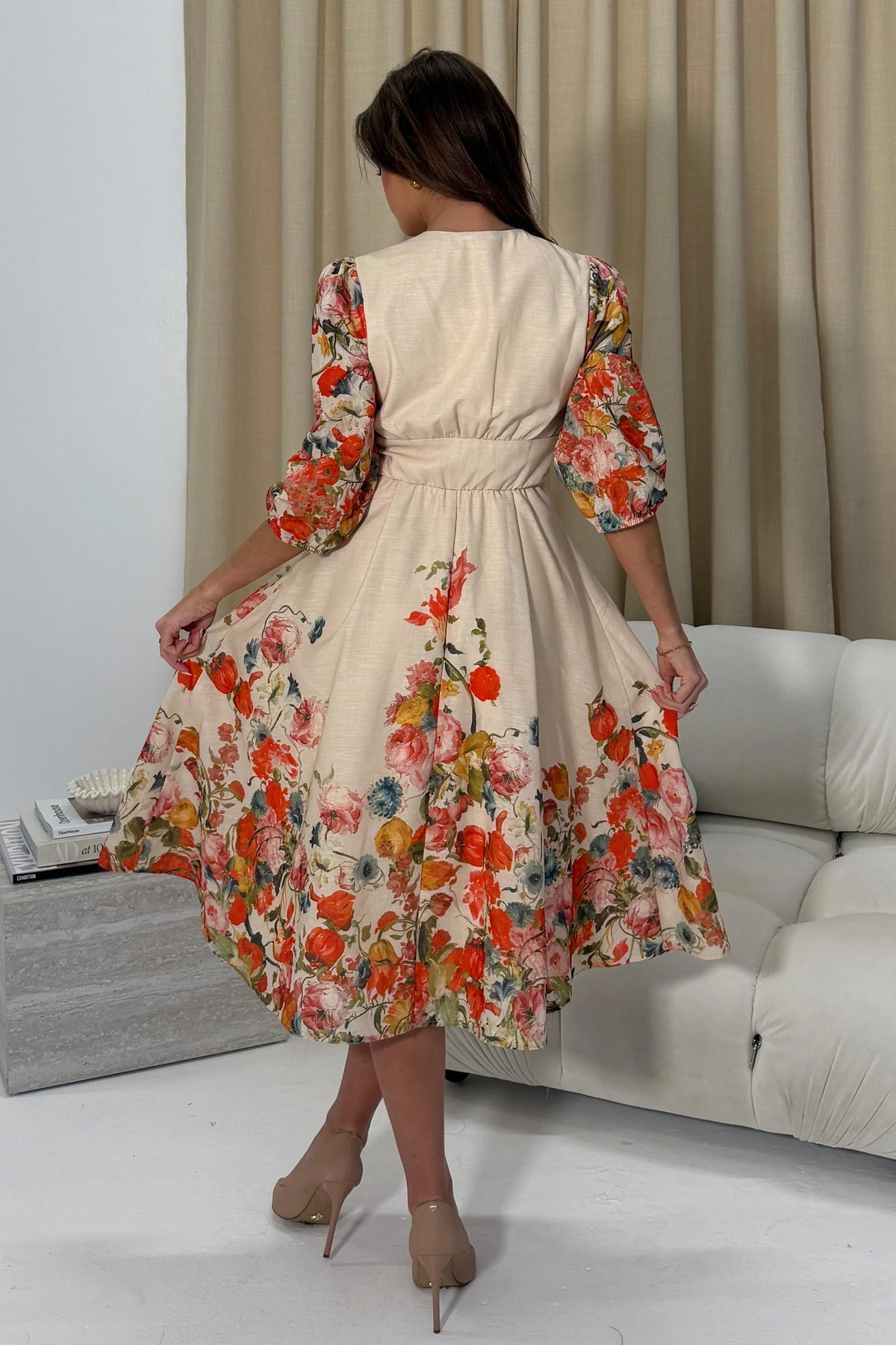 Woman wearing a floral dress in a living room setting