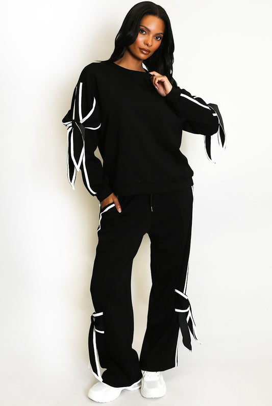 Person wearing a black outfit with white accents on a white background